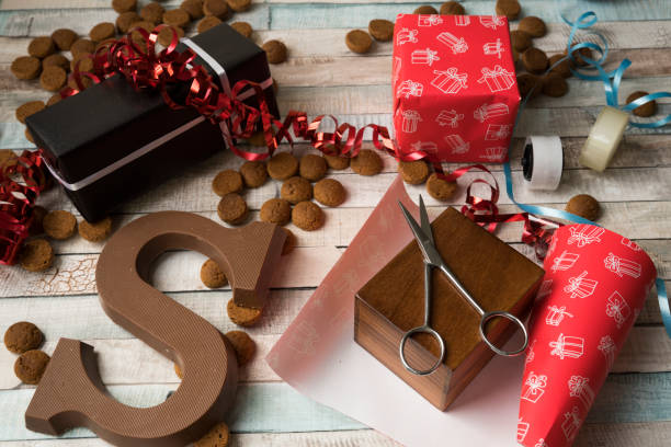 verpakken van een gift voor nederlandse evenement sinterklaas, met kruidnoten, cookies - sinterklaas cadeaus stockfoto's en -beelden