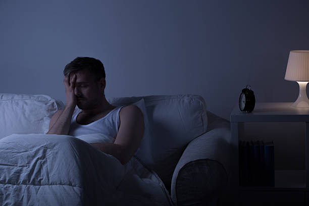 Wretched man suffering from depression View of a man at night suffering from deep depression insomnia stock pictures, royalty-free photos & images