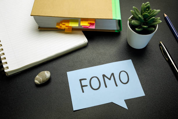 FOMO (fear of missing out) written on paper speech bubble FOMO (fear of missing out) written on paper speech bubble on black table fomo photos stock pictures, royalty-free photos & images