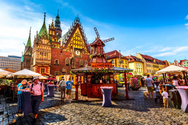 Wroclaw, Poland decorative windmill at Market Square Wroclaw, Poland - June 21, 2019: Old Town Hall and decorative windmill at Market Square, stalls with food and drinks, people wroclaw stock pictures, royalty-free photos & images