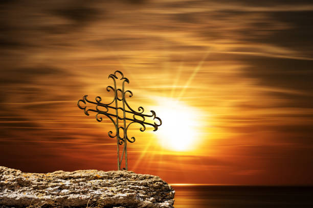 croix religieuse en fer forgé contre un magnifique coucher de soleil sur la mer - good friday photos et images de collection