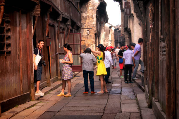 wuzhen town chinese tourists Wuzhen, China. August 30, 2015. A group of chinese tourists on the walkway within Tongxiang wuzhen water town east scenic area in zhejiang province china. wuzhen stock pictures, royalty-free photos & images