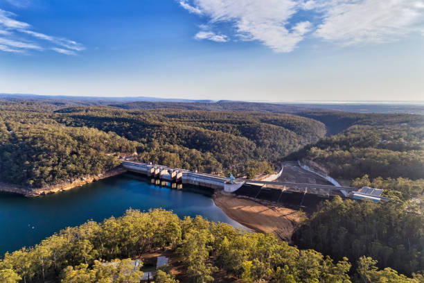 D Wwarragamba From Lake Warragamba dam of Sydney Water supply infrastructure on Nepean river forming fresh water lake between gum-tree woods. Aerial view over dam wall, bridge, gate and surrounding area. dam stock pictures, royalty-free photos & images