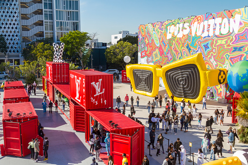 Wynwood, Miami Beach, Florida, USA - December 27, 2020: General landscape view of Louis Vuitton's pop up shops. Nationals and internationals tourists enjoying a warm blue day at Miami Design District - Wynwood, visiting and walking around the Louis Vuitton's containers.\n\nWynwood is a former industrial district of Miami, redeveloped with colorful murals that cover the walls of many of the buildings. In those days, the visitors can find here the most fancy and expensive cafes, restaurants and shops.