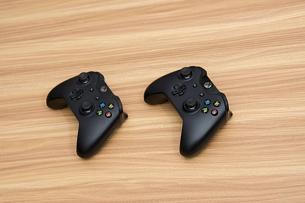 Xbox Game Controllers Melbourne, Australia - June 6, 2016: Xbox Game Controllers, shot on a wooden desk. Xbox is a product of Microsoft Corp.  xbox photos stock pictures, royalty-free photos & images