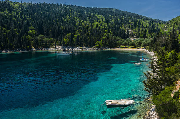 Yacht moored in secluded idyllic greek bay stock photo