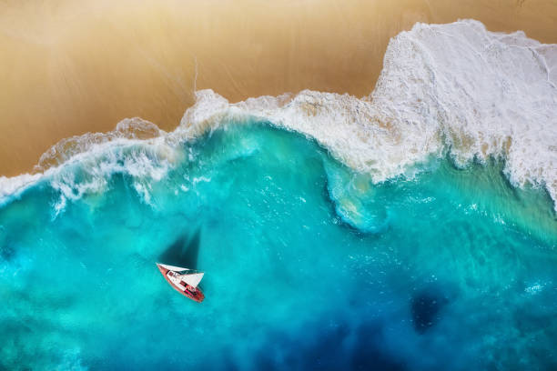 Yacht on the sea from top view. Turquoise water background from top view. Beach and waves. Summer seascape from air. Travel - image stock photo