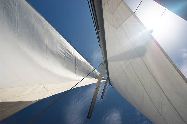 yacht sails against blue sky stock photo