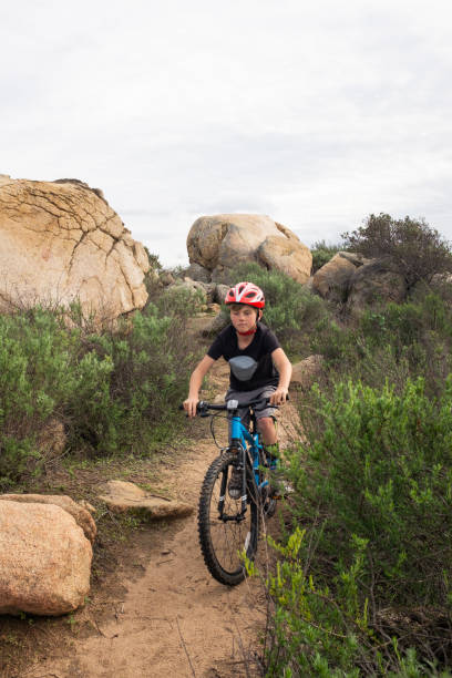 8 Year Old Boy Mountian Biking A boy riding his mountain bike on the trails of Lake Hodges, San Diego California. lake hodges stock pictures, royalty-free photos & images