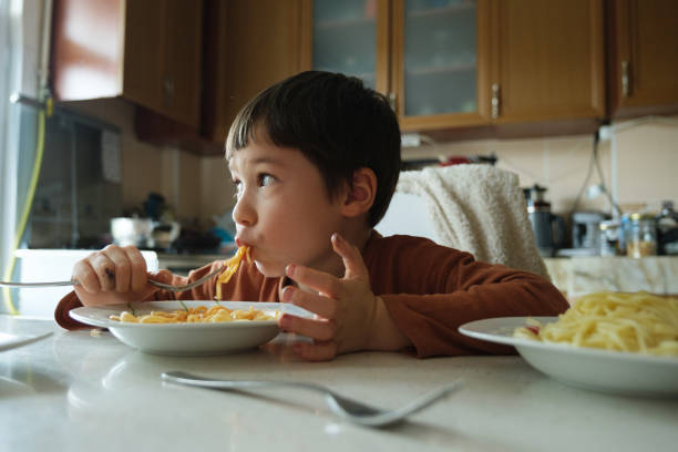 4-5 years cute child eating meal at home with dirty mouth stock photo