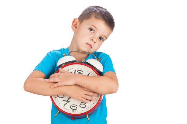 5 years old boy holding an old red clock, isolated on white stock photo