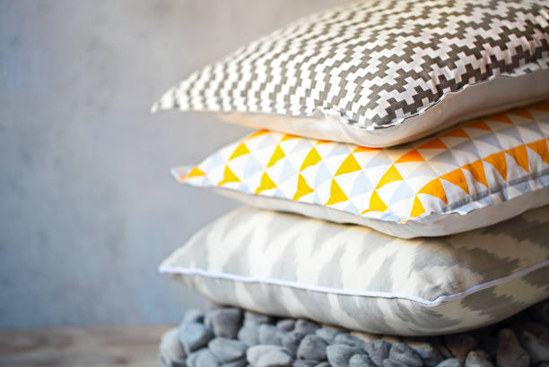 Yellow and grey pillows on the wall background stock photo