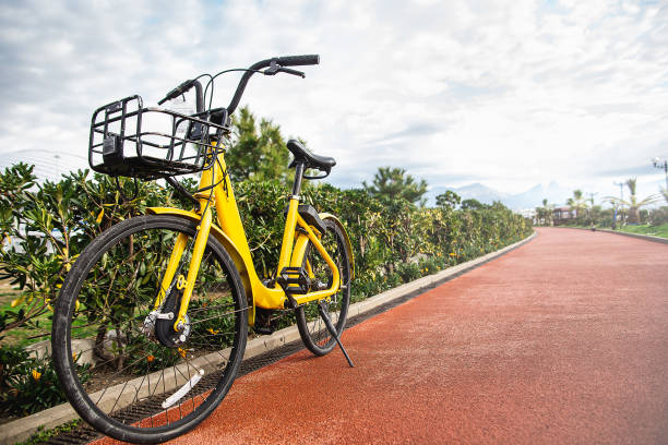 Yellow bike network rental stands on the red bike path stock photo