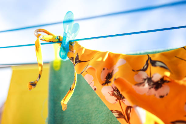 Yellow bikini bottom hanging, drying on the rope in the sunlight. stock photo