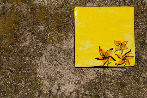 Yellow ceramic tile plaque on stone wall stock photo