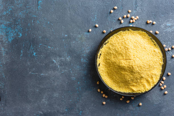 Yellow chickpea flour in black ceramic bowl on dark background top view copy space Yellow chickpea flour in black ceramic bowl on dark background top view copy space pea protein powder stock pictures, royalty-free photos & images