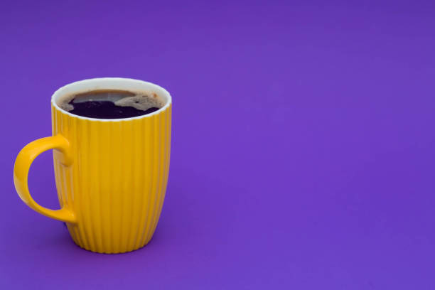 tasse de café jaune sur un fond violet à la mode. le concept du mot « happy friday ». - the game photos et images de collection