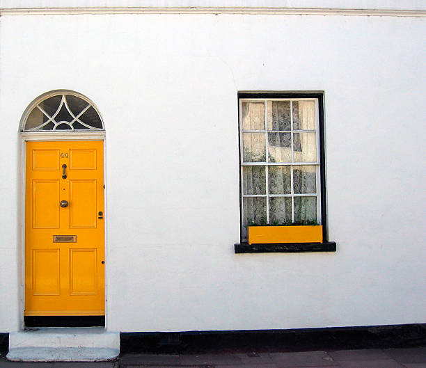 Yellow door and window box on white building Yellow front door and window (London) yellow front main door stock pictures, royalty-free photos & images