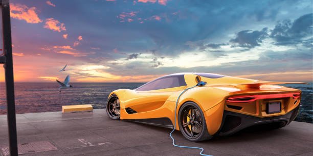 Yellow Electric Sports Car Charging From Cable On Parking Spot Overlooking Sea At Dawn stock photo