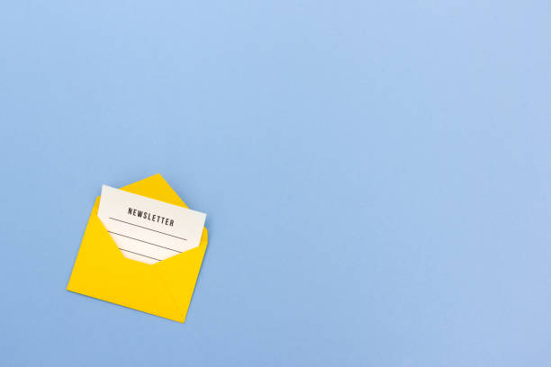 Yellow envelope with newsletter on blue background stock photo