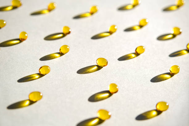 Yellow gel transparent gel capsules of vitamin d or omega 3 in spoon. stock photo