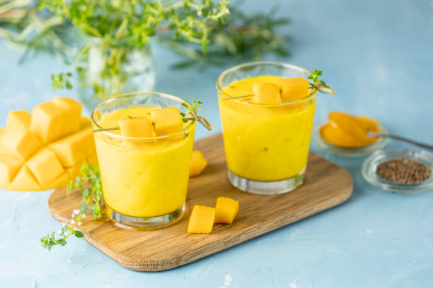 Yellow Indian mango yogurt drink Mango Lassi or smoothie with turmeric and saffron stock photo