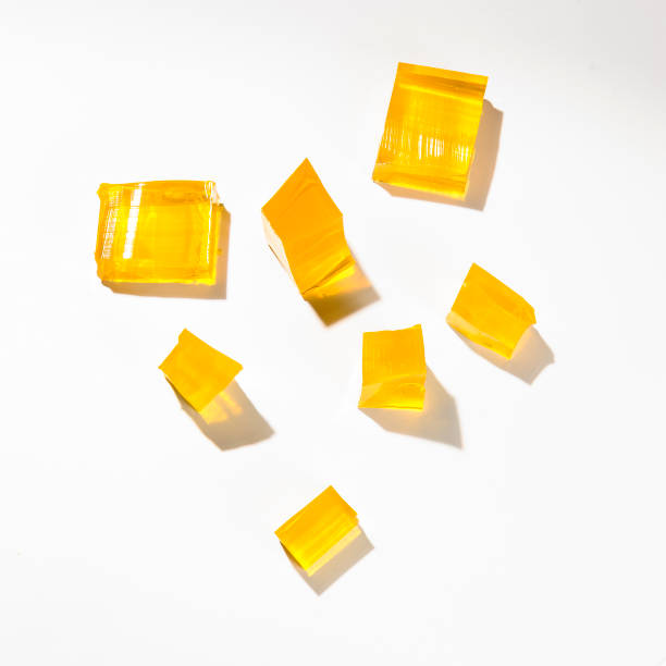 Yellow jelly Misshapen pieces of yellow jelly, isolated on a white background gelatin stock pictures, royalty-free photos & images