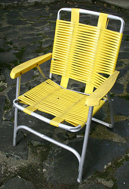 yellow lawn chair on patio stock photo