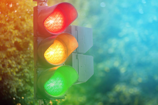 Yellow light of traffic lights in summer city stock photo