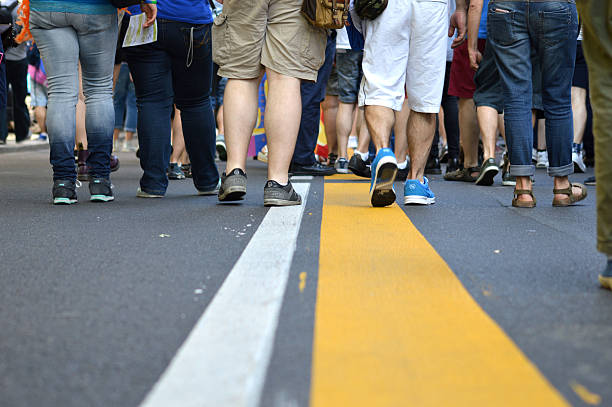 linea gialla con folla che cammina lungo - pride milano foto e immagini stock