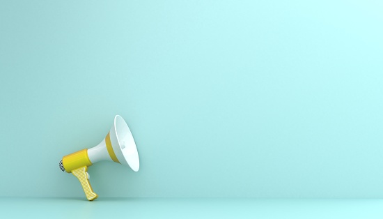 Yellow megaphone on light blue background. Copy space for announcement concepts.