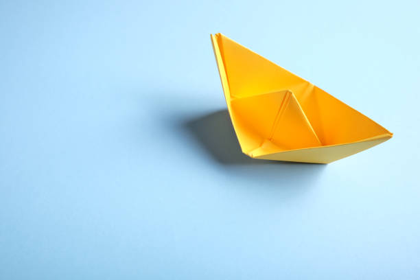 Yellow origami boat on blue. Yellow ship on blue water. Yellow origami boat on blue. Yellow ship on blue water. aqua menthe photos stock pictures, royalty-free photos & images