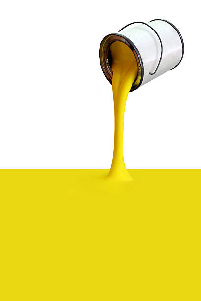 Yellow paint pours from silver can stock photo