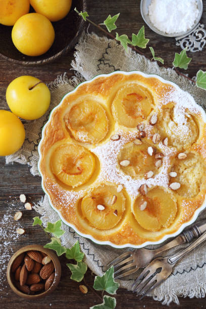 Yellow plums clafoutis (flan) with almonds, icing sugar dressing, french cuisine stock photo