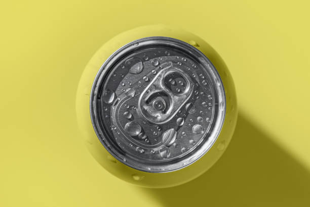 Yellow pop can with water drops casting shadow on yellow background stock photo