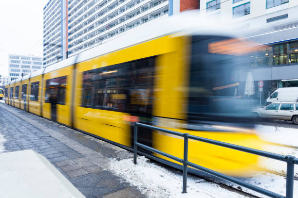 gele tram met wazig beweging op alexanderplatz in berlijn, duitsland - berlin snow stockfoto's en -beelden