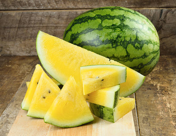 Yellow watermelon  sliced on wooden background stock photo