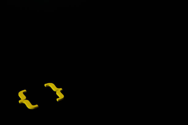 Yellow wooden symbol "bracket" on black background stock photo