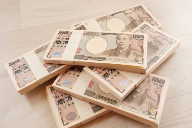 10,000 yen bills A large quantity of Japanese 10,000 yen bills. Multiple wads of bills. BANK OF JAPAN   stock pictures, royalty-free photos & images