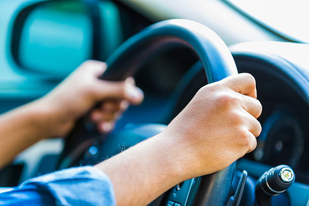 yes, key to safe driving, both hands on the wheel. - driver stockfoto's en -beelden