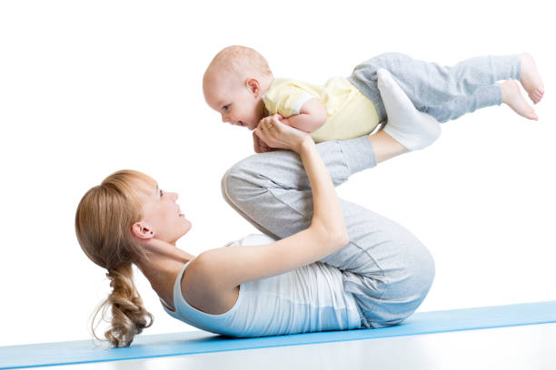 Yoga for woman and baby. Mother with child boy doing stock photo