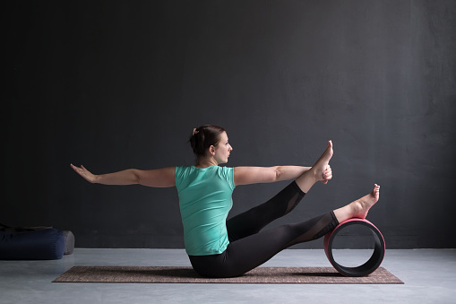 yoga-girl-doing-parivrtta-navasana-or-twisted-boat-pose-picture-id1130565561?b=1&k=20&m=1130565561&s=170667a&w=0&h=a-aEOZRR5AXdwxb2udYSRHL36ZuczGYeVuOGfVgFlr8=