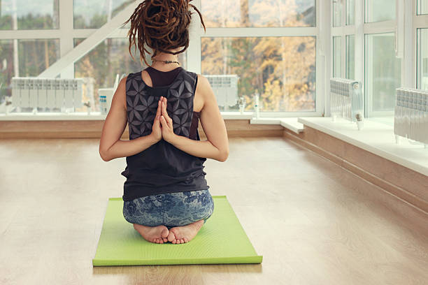 Yoga pose. A girl practice yoga in a bright room. stock photo