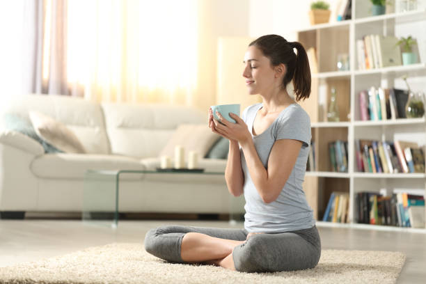 yogui bebiendo té después de los ejercicios de yoga en casa - gente tranquila fotografías e imágenes de stock