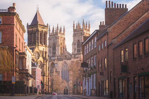 Morning golden light on the historic old town of York along Museum St. looking towards York Minster Cathedral.