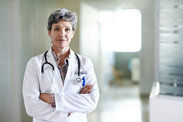 You are in capable hands Portrait of a mature female doctor standing in a hospital corridorhttp://195.154.178.81/DATA/i_collage/pu/shoots/804719.jpg female doctor stock pictures, royalty-free photos & images