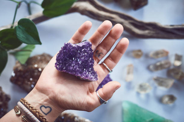 You are the right one Closeup of an unrecognizable person holding a crystal with two hands over a table filled with more crystals inside during the day amethyst stock pictures, royalty-free photos & images