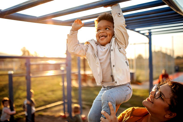 You can do it Kid playing with mother in public park african american children stock pictures, royalty-free photos & images