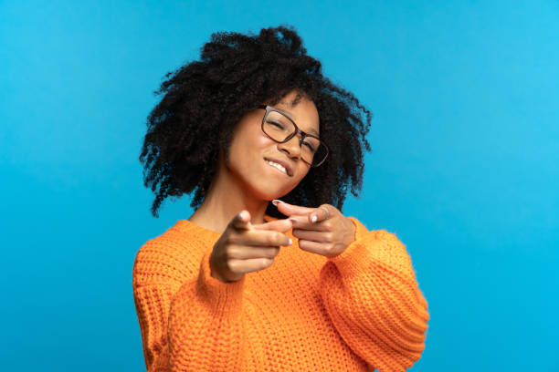You what we need: black woman choose you point fingers front. Happy black female gesture to camera stock photo