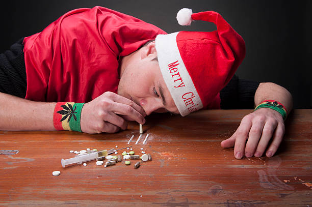 Young addicted guy dressed in Christmas clothes Young addicted guy dressed in Christmas clothes and snoring heroine snorting stock pictures, royalty-free photos & images